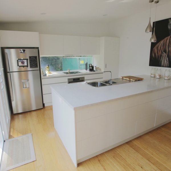 Modern kitchen design featuring a minimalist layout, white cabinetry, stainless steel appliances, and a spacious island, emphasizing family-friendly and sustainable living.