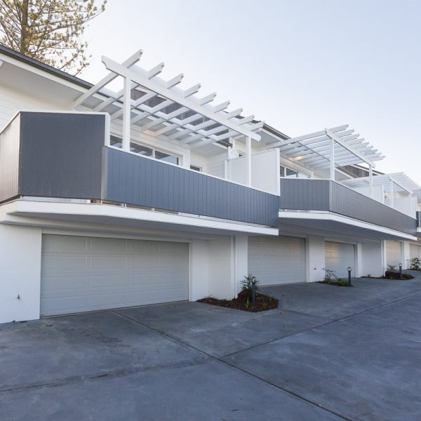 Modern duplex homes with eco-friendly design and premium finishes, featuring spacious balconies and garage spaces, part of the Seabreeze housing development by Living Green Designer Homes.