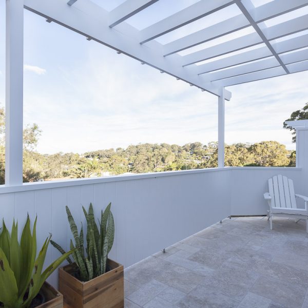 Balcony view of the 'Seabreeze' housing development by Living Green Designer Homes, featuring modern design elements, potted plants, and a scenic landscape.