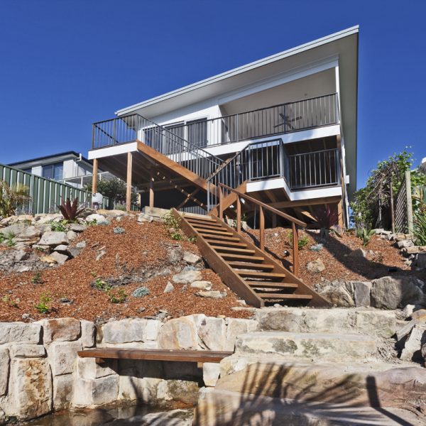 Sustainable River View Home with wooden stairs, landscaped garden, and modern design by Living Green Designer Homes.