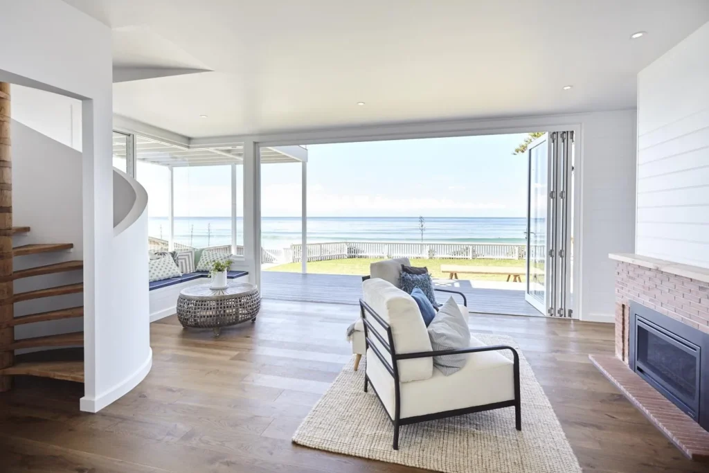Custom home open-plan living room with bifold doors opening to a Central Coast beachfront