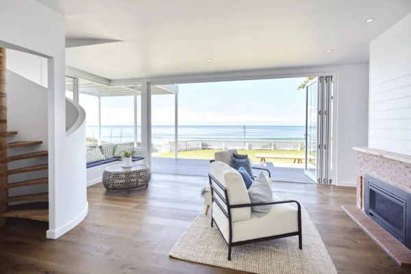 Custom home open-plan living room with bifold doors opening to a Central Coast beachfront
