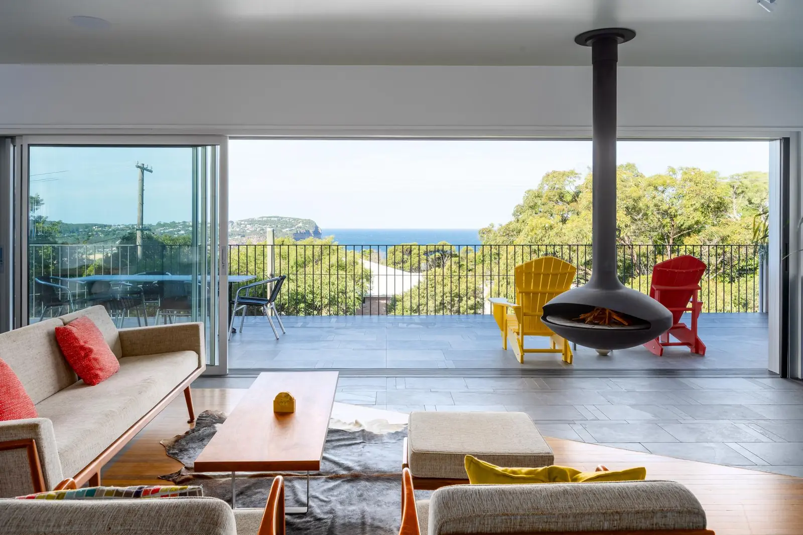 Custom home living area with a suspended fireplace and elevated ocean views on the Central Coast