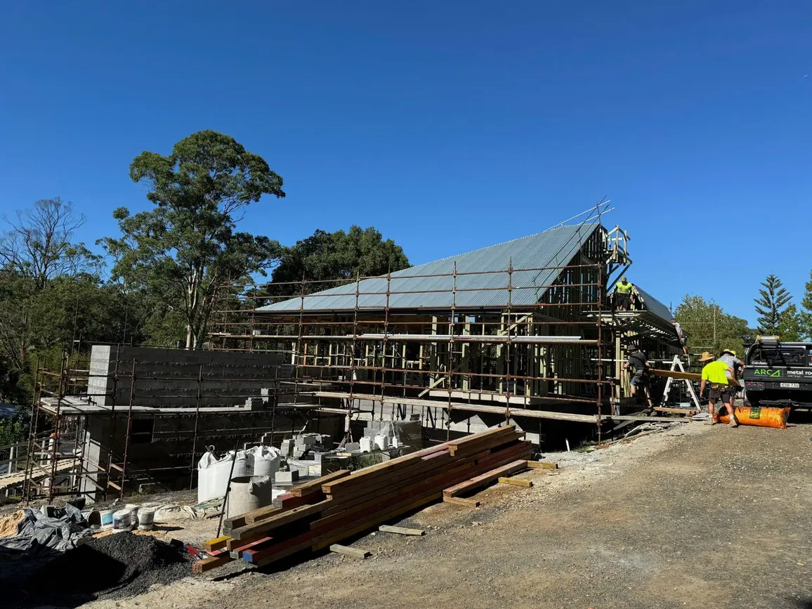 New custom home under construction with timber framing and scaffolding on the Central Coast